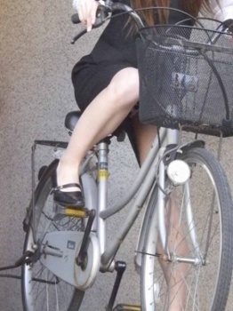 スカートで自転車に乗るスーツ姿のOLさんの画像