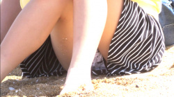 【eros1936座りパンチラ】砂浜でお友達とおしゃべり中にスヌー●ー柄Pを座りパンチラしてしまう若い娘の画像