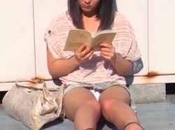 《パンチラ動画》地べたに座って読書中の可愛い女子を隠し撮り盗撮の画像
