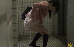【着衣放尿】トイレ個室前で立ちお漏らしする女性を盗撮。地面をおしっこでビシャビシャに濡らすｗの画像